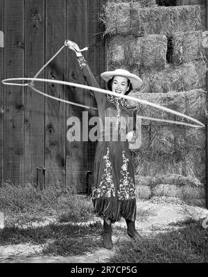 Hollywood, California: c. 1954 attrice Ann Blyth mostra le sue abilità di filatura della corda della cowgirl. Foto Stock