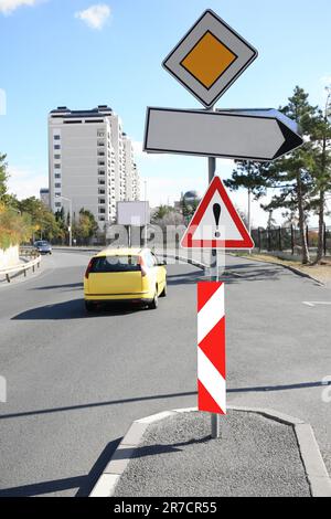 Posta con diverse indicazioni stradali sulla strada cittadina Foto Stock