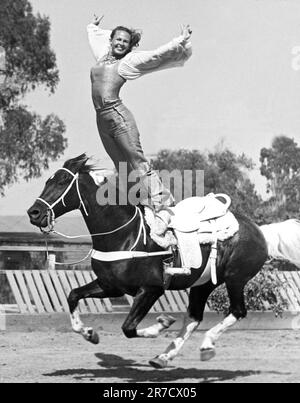 Los Angeles, California: 1955. Stunt donna Donna Hall fare una stanzetta romana su un cavallo galoppante. Foto Stock