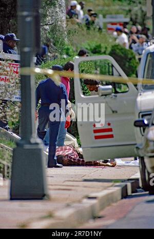 WASHINGTON DC - 19 APRILE 1993 gli investigatori di omicidi della polizia DC guardano sopra il corpo di 61 anni nello Hughes l'ultima vittima del ÒShotgun StalkerÓ James E. Swann Jr Foto Stock