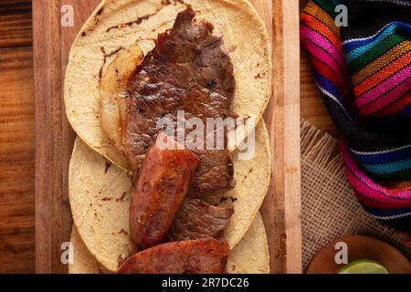 Taco campechano stile, Carne Asada. (Carne arrosto) e chorizo o longaniza, piatto molto popolare nel Messico settentrionale, chiamato anche Asado, Discada o Parrill Foto Stock