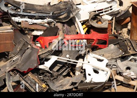 paraurti rotti e parti di automobili sulla strada come spazzatura Foto Stock