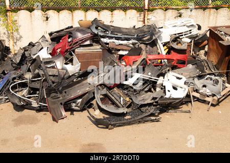 paraurti rotti e parti di automobili sulla strada come spazzatura Foto Stock