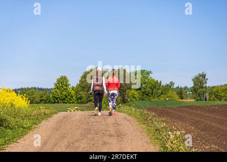 Camminare le donne su una strada sterrata in campagna Foto Stock