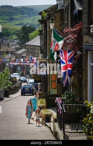 Haworth, West Yorkshire, Regno Unito. La vista lungo Main Street nel popolare villaggio West Yorkshire di Haworth. Foto Stock