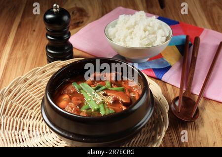 Zuppa di kimchi in una calda zuppa di ferro nera, zuppa di kimchi jigae tradizionale coreana. Hot Pot cibo giapponese. Servito con riso. Messa a fuoco selezionata Foto Stock