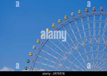 Una vista panoramica di una ruota panoramica contro il cielo blu in una giornata di sole Foto Stock