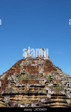 Rovine medievali di un'antica piramide di pietra in Cambogia, adagiato contro il cielo limpido del Sud-est asiatico. Foto Stock