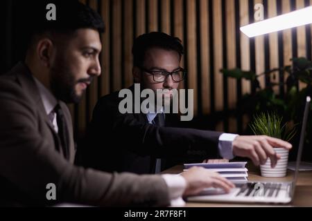 Due lavoratori di mezza età lavorano alla scrivania in un ufficio. Foto Stock