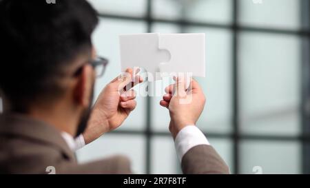 Uomo d'affari cercando di collegare pezzi puzzle closeup Foto Stock