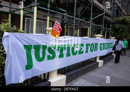 Londra, Regno Unito. 14th giugno, 2023. Una bandiera di Justice for Grenfell è raffigurata sulla strada del Grenfell Silent Walk dai membri della comunità di Grenfell intorno a West Kensington. L'evento è stato organizzato per celebrare il sesto anniversario dell'incendio della Grenfell Tower il 14 giugno 2017, per cui sono morte 72 persone e oltre 70 sono state ferite. L'inchiesta sulla Torre di Grenfell ha concluso nel novembre 2022 che tutte le morti nell'incendio erano evitabili, ma non sono ancora state portate a termine azioni penali. Credit: Notizie dal vivo di Mark Kerrison/Alamy Foto Stock