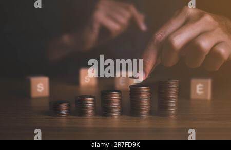 La mano che mette la moneta di soldi su ogni linea che aumenta - concetto di soldi di risparmio di affari per la contabilità finanziaria. Risparmiare e far crescere la finanza. Foto Stock