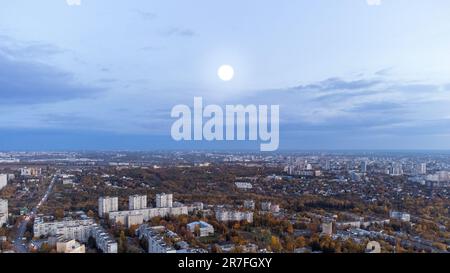 Vista aerea della città autunno sera con grande luna bianca. Quartiere residenziale con parco e cielo nuvoloso panoramico. Kharkiv, Ucraina Foto Stock