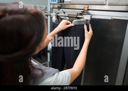 Servizio di lavanderia indossando pantaloni sul manichino da stiro Foto Stock