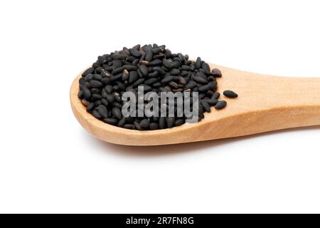 Cucchiaio di legno con semi di sesamo arrostiti in primo piano isolato su fondo bianco Foto Stock