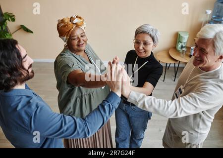 Gruppo di persone anziane alto cinque mentre festeggia il successo togethet Foto Stock