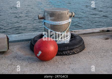 Fotografia di corda bianca avvolta intorno a un paletto di acciaio con una boa rossa sull'ormeggio a King Island nello stretto di Bass della Tasmania in Australia Foto Stock