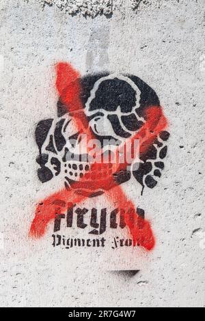Croce rossa sul pigmento aryan Graffiti stencil frontale su superficie in cemento nel distretto di Merihaka di Helsinki, Finlandia Foto Stock