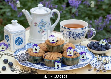 muffin ai mirtilli vegani al mirtillo sul piatto e set da tè bianco blu Foto Stock