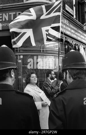 I sostenitori del National Front vendono il National Front News, ogni domenica mattina all'incrocio tra Brick Lane e Bethnal Green Road. Londra. C'era una situazione di stallo regolare, con la polizia e i membri del Partito Socialista dei lavoratori che vendevano il loro giornale settimanale. Whitechapel, Londra est, Inghilterra 1976. 1970S UK HOMER SYKES Foto Stock