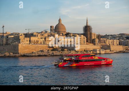 City Sightseeing Malta Red Boat Cruise Porto, sullo sfondo skyline della città di Valletta al tramonto, Malta Foto Stock