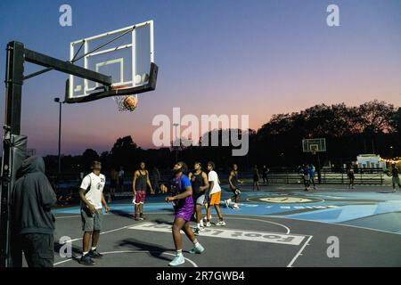 Meteo britannico, Clapham, Londra, 15 giugno 2023: In una leggera serata estiva dopo una giornata calda, i giocatori di basket si avvalgono dei campi illuminati di Clapham Common per esercitarsi. Credit: Anna Watson/Alamy Live News Foto Stock