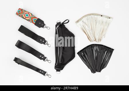 Banana Fanny Pack in vera pelle nera con quattro tipi di cinghie agganciabili e due frange agganciabili. Borsa piatta personalizzabile su sfondo grigio Foto Stock