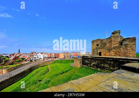 Tynemouth Front St e il castello dai bastioni del castello sopra l'incantevole King Edwards Bay Foto Stock