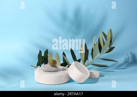 Vasetti di crema d'oliva su sfondo azzurro. Prodotti cosmetici Foto Stock