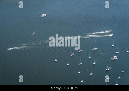 Vista aerea di molte piccole imbarcazioni e imbarcazioni ancorate con altre che navigano e passano sulle acque blu della baia di Guanabara in una giornata di sole d'estate. Foto Stock