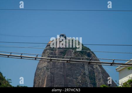 Vista in lontananza della stazione della funivia Sugarloaf sulla cima del monte Sugarloaf, punto di riferimento naturale nel distretto di Urca, sotto il cielo azzurro e soleggiato d'estate. Foto Stock