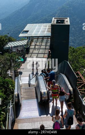 Un gruppo di turisti che lasciano l'area del ponte del Cristo Redentore utilizzando una delle scale mobili sulla cima del monte Corcovado durante il soleggiato giorno estivo. Foto Stock