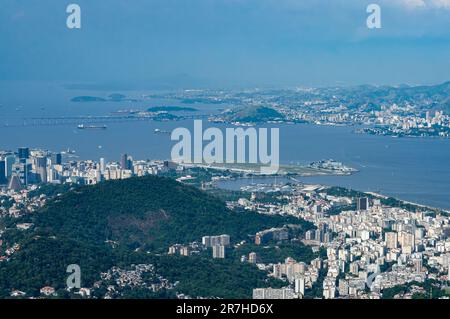 Vista aerea a distanza dei quartieri Centro e Gloria con l'aeroporto Santos Dumont al centro vista dalla cima del monte Corcovado sotto il cielo blu estivo. Foto Stock