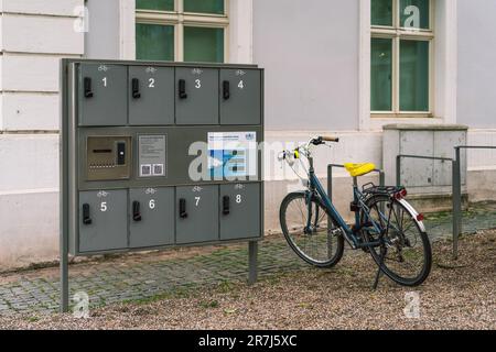 Armadietti per stazioni di ricarica di biciclette elettriche a energia solare in piazza Schlossplatz a Saarbrücken, Germania Foto Stock