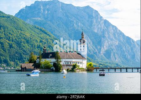 Schloss Ort castello vicino Traunsee, Austria. Vista sull'antico castello con lungo ponte sul lago. Famosa destinazione turistica. Foto Stock