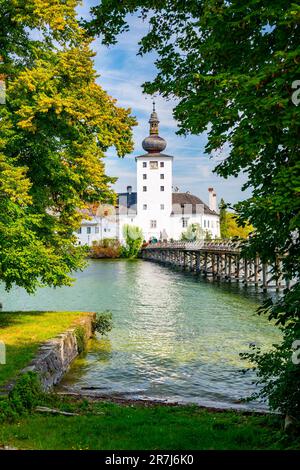 Schloss Ort castello vicino Traunsee, Austria. Vista sull'antico castello con lungo ponte sul lago. Famosa destinazione turistica. Foto Stock