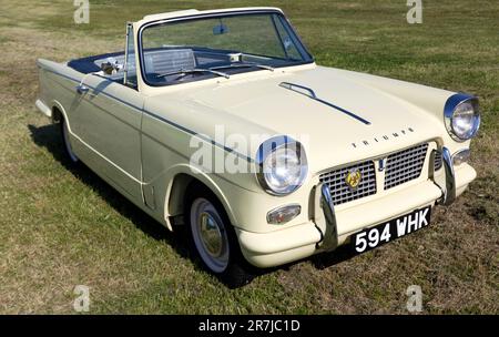 Tre quarti della vista frontale di a Cream, 1961, Triumph Herald Convertibile, in mostra al 2023 Deal Classic Car Show Foto Stock