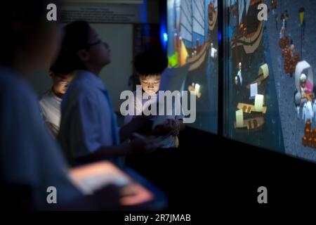 Gli studenti di Singapore utilizzano la tecnologia di immersione 4D in un laboratorio informatico durante una lezione di arricchimento delle vacanze estive. Foto Stock