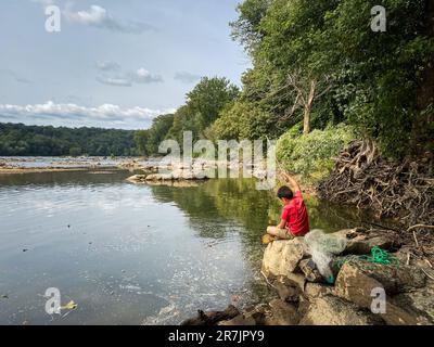 Ragazzo pesca in fiume in una giornata d'estate. Foto Stock