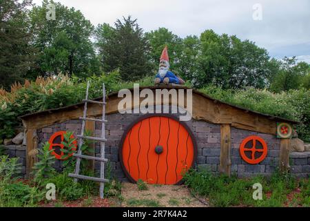 Gnomo scandinavo decorativo che si posa sulla cima di una casa tipo hobbit con una scala a Sven Factory Outlet Store a Chisago City, Minnesota USA. Foto Stock