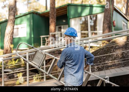 Scaletta da lavoro con elmetto Foto Stock