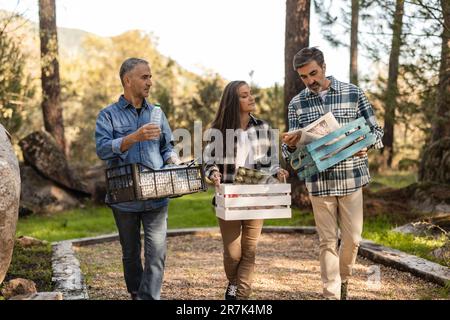 Amici che trasportano casse con scarti separati Foto Stock