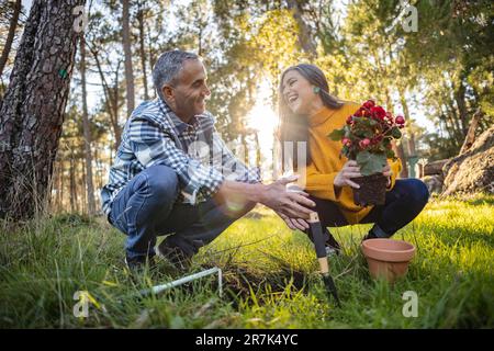 Felice coppia matura piantando fiore in giardino naturale Foto Stock