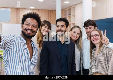 Buon team di lavoro in posa per un selfie in ufficio Foto Stock