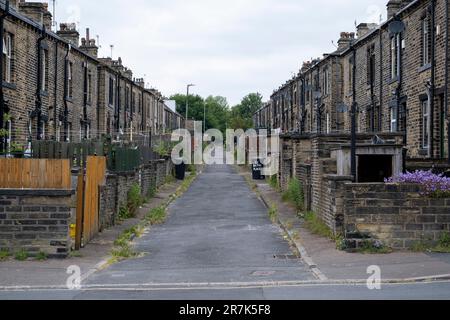 Vicolo posteriore dove i bidoni sono tenuti al di fuori dei vecchi cottage operai mulino all'interno delle strade terrazzate di Woodside, parte della zona di Boothtown il 6th giugno 2023 a Halifax, Regno Unito. Boothtown è un sobborgo all'interno della città di Ward di Halifax, molto vicino al centro della città. La sua storia fu dominata dai mulini dell'industria tessile. Halifax è una città situata nel distretto di Calderdale, nello Yorkshire occidentale, ed è stata una fiorente cittadina di mulini durante la rivoluzione industriale. Al giorno d'oggi, mentre la città sta mostrando segni positivi di rigenerazione in alcune aree, la crisi economica nel Regno Unito e altri fattori recenti è resul Foto Stock