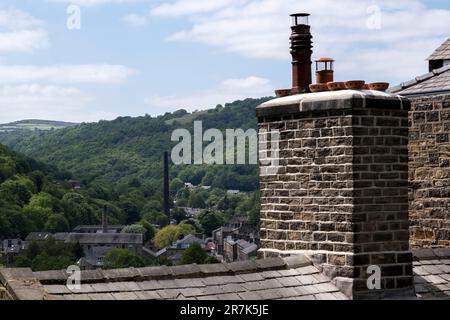 Scena di vecchi edifici di mulini industriali dall'alto il 7th giugno 2023 a Hebden Bridge, Regno Unito. Nei secoli 19th ° e 20th ° la città è stata conosciuta come Città stirapantaloni a causa della grande quantità di stoffa che è stato fabbricato presso i mulini. La posizione di Hebdens nella valle con i corsi d'acqua e i vicini mercati della lana lo hanno reso un luogo ideale per la produzione di tessuti. Hebden Bridge è una città commerciale situata nella Upper Calder Valley, nello Yorkshire occidentale. Durante gli anni '1970s e '1980s la città ha visto un afflusso di artisti, creativi e professionisti alternativi, nonché di attivisti verdi e del New Age. Più recentemente, la ricchezza Foto Stock