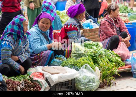 Bac ha, Vietnam-Aprile 2023; Vista di un certo numero di donne da Hmong fiore e Giay persone che vendono verdura sul mercato Domenica Bac ha Foto Stock