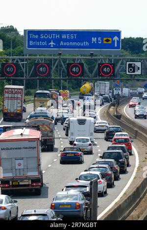 Bristol, Regno Unito. 16th giugno, 2023. Caldo e soleggiato sull'autostrada affollata. Un weekend di sole fughe causa congestione del traffico sulla M5 tra gli incroci 15/16 e 17. Autostrade l'Inghilterra riferisce le velocità negli anni '20. Le restrizioni di velocità gestite in autostrada sono in vigore a causa del volume di traffico che si dirige a sud verso Devon e Cornovaglia per il fine settimana. Credit: JMF News/Alamy Live News Foto Stock