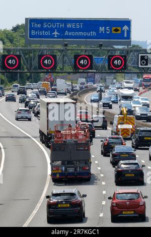 Bristol, Regno Unito. 16th giugno, 2023. Caldo e soleggiato sull'autostrada affollata. Un weekend di sole fughe causa congestione del traffico sulla M5 tra gli incroci 15/16 e 17. Autostrade l'Inghilterra riferisce le velocità negli anni '20. Le restrizioni di velocità gestite in autostrada sono in vigore a causa del volume di traffico che si dirige a sud verso Devon e Cornovaglia per il fine settimana. Credit: JMF News/Alamy Live News Foto Stock