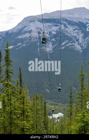 Banff, AB, Canada-Agosto 2022; vista verticale ad angolo alto di un certo numero di gondole o funivie di Banff Gondola con le montagne come sfondo Foto Stock